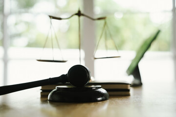 A judge's gavel placed on a wooden desk beside a laptop, symbolizing law, justice, court decisions, and legal proceedings in a modern office.