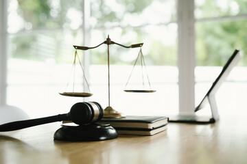 A judge's gavel placed on a wooden desk beside a laptop, symbolizing law, justice, court decisions,...