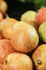Fresh Ripe Guavas from Fujian with Soft Red Skin on Wooden Surface - Tropical Fruit Close-up