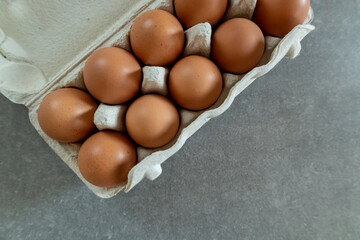 brown eggs in a carton on gray kitchen countertop