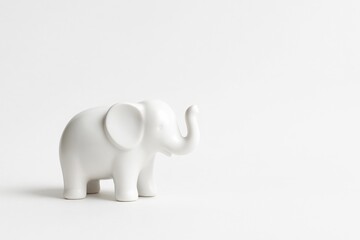 White ceramic elephant figurine on clean background with soft shadow and copy space minimal concept of wisdom strength stability and business strategy