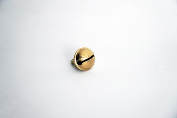 A single, vintage golden jingle bell sits on a clean white background, perfect as a graphic element...