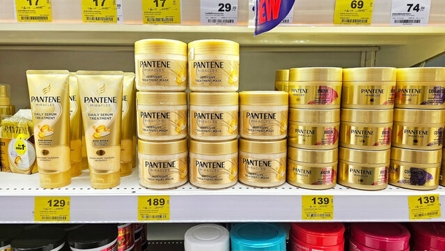 Shelves display various Pantene hair care products, including shampoos, conditioners, and treatments, all featuring golden packaging, Thailand, September 24, 2025
