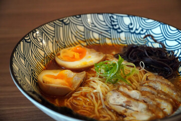 A mouthwatering close-up of a bowl of Japanese ramen with rich broth, noodles, sliced chicken, and a soft-boiled egg. This vibrant image is perfect for themes of Asian cuisine, culinary art, and comfo