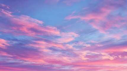 Fototapeta premium A serene sky filled with pastel pink and blue clouds at twilight or dawn