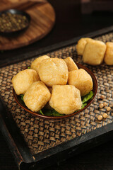 Golden Fried Tofu Puffs in Wooden Bowl on Bamboo Mat - Traditional Asian Food