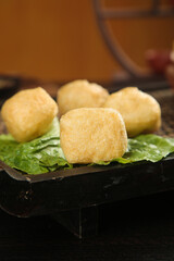 Golden Fried Tofu Puffs on Green Leaves - Traditional Asian Vegetarian Cuisine