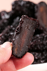 Dried Black Jujube Fruit Held in Hand - Traditional Chinese Medicine Ingredient with Natural Crystal-Like Texture