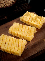 Fresh Sliced Soybean Tofu Products on Wooden Cutting Board - Traditional Asian Food Preparation