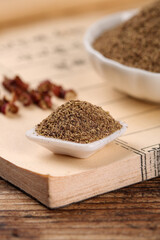 Finely Powdered Black Pepper in Ceramic Spoon on Wooden Board with Dried Peppercorns