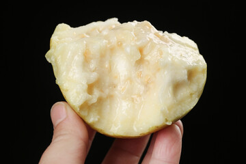 Fresh White Guava Fruit Half Held in Hand Against Black Background