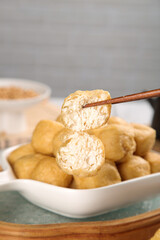 Golden Fried Tofu Puffs in White Dish with Chopsticks - Asian Vegetarian Food