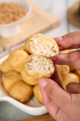 Golden Fried Tofu Puffs with Fluffy Interior Texture in Hand - Asian Bean Curd Cooking Preparation