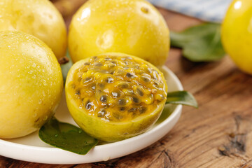 Fresh Golden Passion Fruit from Hainan China Cut Open Showing Seeds and Honey-Colored Pulp on Wooden Table