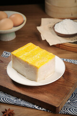 Handmade White Cake with Golden Topping and Baking Ingredients on Rustic Wooden Board