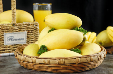 Fresh Golden Vietnamese Mangoes in Wicker Basket with Tropical Fruit Juice Display
