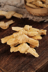 Traditional Dried Bean Curd Sticks Tied in Knots on Wooden Background - Asian Food Ingredient