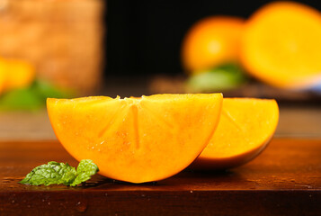 Fresh Sliced Persimmon Fruit with Mint Leaves on Wooden Board - Fall Harvest Food Photography