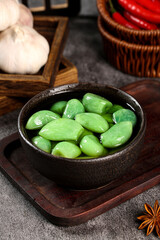Fresh Green Pickled Vegetables in Ceramic Bowl with Garlic and Spices on Rustic Wood Surface