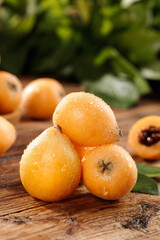 Fresh Alpine Loquat Fruits from Panzhihua - Golden Organic Produce with Water Droplets on Wooden Background