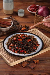 Traditional Chinese Stir-Fried Dried Vegetables with Salted Plum and Peanuts on Wooden Table