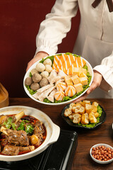 Chef Serving Hot Pot with Lamb Stew and Asian Side Dishes