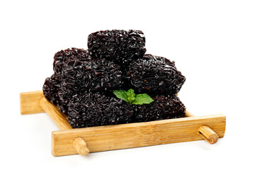Large Black Dried Xinjiang Dates on Wooden Tray with Fresh Mint Garnish