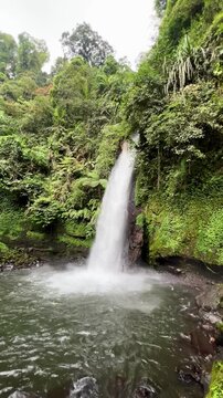 Curug Sawer, also known as Sawer Waterfall, surrounded by lush greenery, offering a refreshing and natural environment. Located within Situ Gunung in Sukabumi Regency, Indonesia.