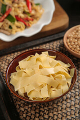 Handmade Tofu Skin Sheets Raw Asian Food Ingredient in Ceramic Bowl on Bamboo Mat