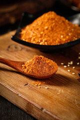 Spicy Sichuan Chili Powder Hot Pot Base Seasoning on Wooden Spoon - Traditional Chinese Cooking Ingredients