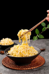 Braised Sauerkraut in Black Bowl with Chopsticks on Dark Background