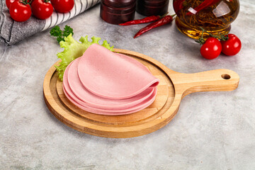 Sliced boiled sausage over board