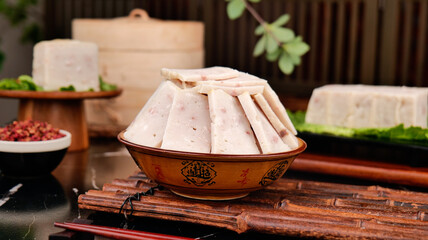 Traditional Chinese White Cake Slices in Decorative Bowl with Tofu and Asian Cooking Ingredients on...
