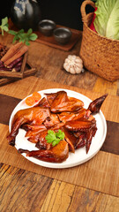 Chinese Roast Duck with Soy Sauce and Herbs on Wooden Table