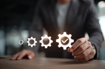 A person holds a translucent gear icon with a checkmark, with smaller gear icons behind it, against an abstract blurred background