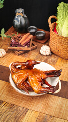 Traditional Chinese Roasted Duck with Tea Set and Fresh Vegetables on Wooden Table