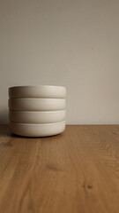 Stack of minimalist ceramic bowls on a wooden surface