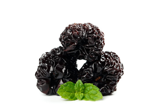 Black dried dates with fresh mint leaves isolated on white background