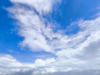 Sky with a cityscape beneath a wide, partly cloudy