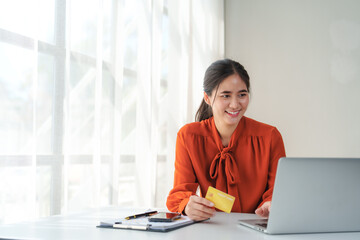 Smiling businesswoman using credit card and laptop for online shopping