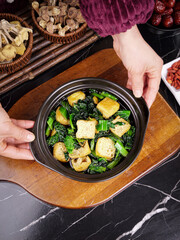 Traditional Asian Clay Pot Cooking with Tofu and Green Vegetables Stir Fry Dish