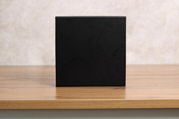 Black box product mockup on wooden desk