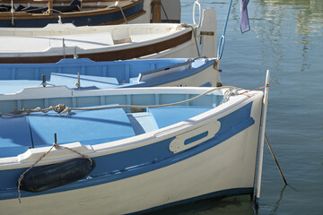 peaceful marina scene with a row of small boats docked side by side, their stern facing the viewer in Cassis, Provence, France