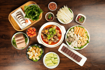 Hot pot ingredients with lamb bone broth, enoki mushrooms, tofu and vegetables for traditional Asian cooking