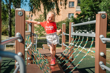 Obraz premium Little child girl on the playground in summer