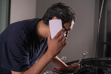 Asian man Stressed Over Vehicle Malfunction.