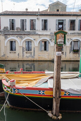 votive shrine on dockage pole in Vena canal, Chioggia, Italy