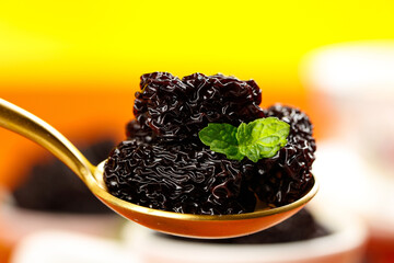 Xinjiang Black Dried Dates with Mint Leaf on Golden Spoon - Premium Organic Fruit Snack © LamHuong