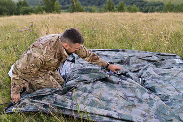 Traveler assembling tent during mountain camping