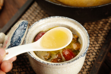 Nutritious Chinese Chicken Soup with Yam and Red Dates Being Served from Traditional Clay Pot